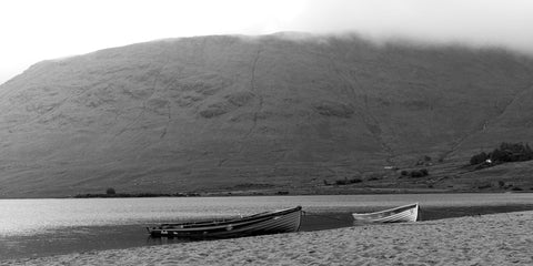 A pair of boats on the sand in the rain at Lough Nafooey in County Galway. Lough Nafooey is a rectangular shaped glacial lake on the border of County Mayo and County Galway.