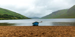A single blue boat sits on sand in the rain at Lough Nafooey in County Galway. Lough Nafooey is a rectangular shaped glacial lake on the border of County Mayo and County Galway.