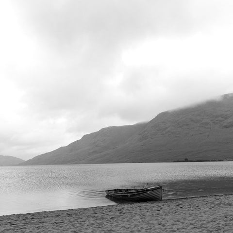Calm. A single boat on the sand in the rain at Lough Nafooey in County Galway. Looking towards the Mayo border.  Lough Nafooey is a rectangular shaped glacial lake on the border of County Mayo and County Galway.